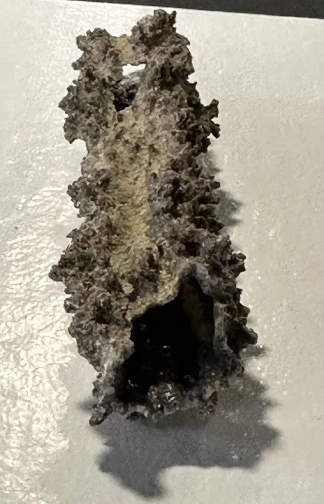 dark gray fulgurite glass tube, open end