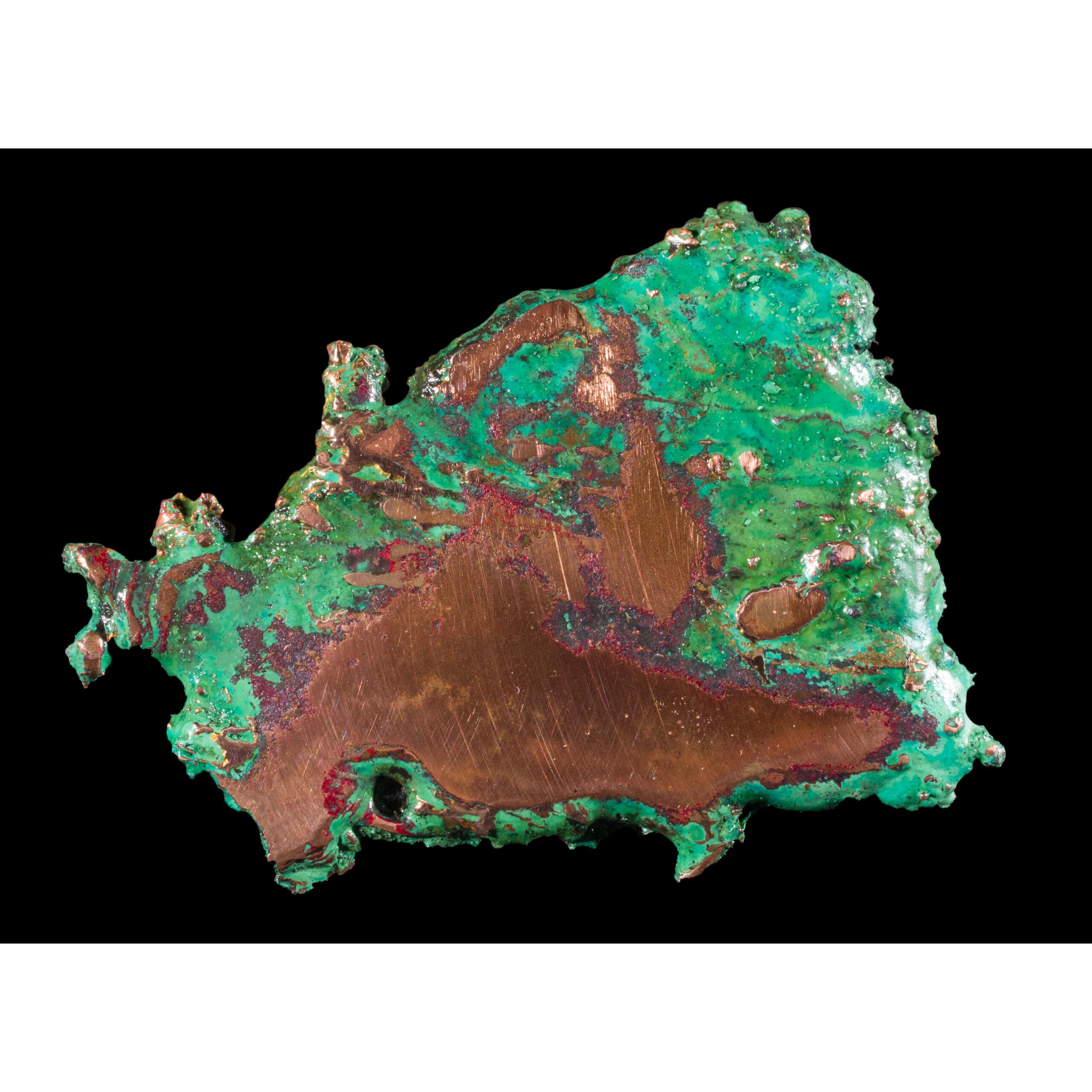 This is a picture of a piece of polished copper, possessing a large quantity of vibrant green oxidization.