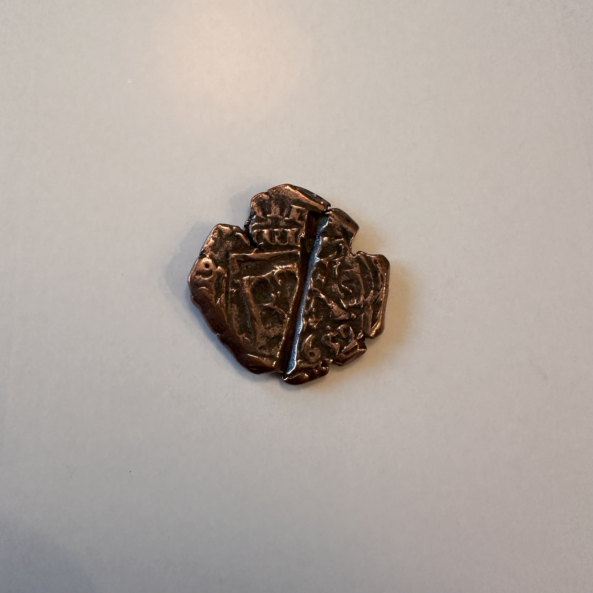 Spanish pirate cob coin. This coin has a score line where someone attempted to cut it probably for payment in the 17th century