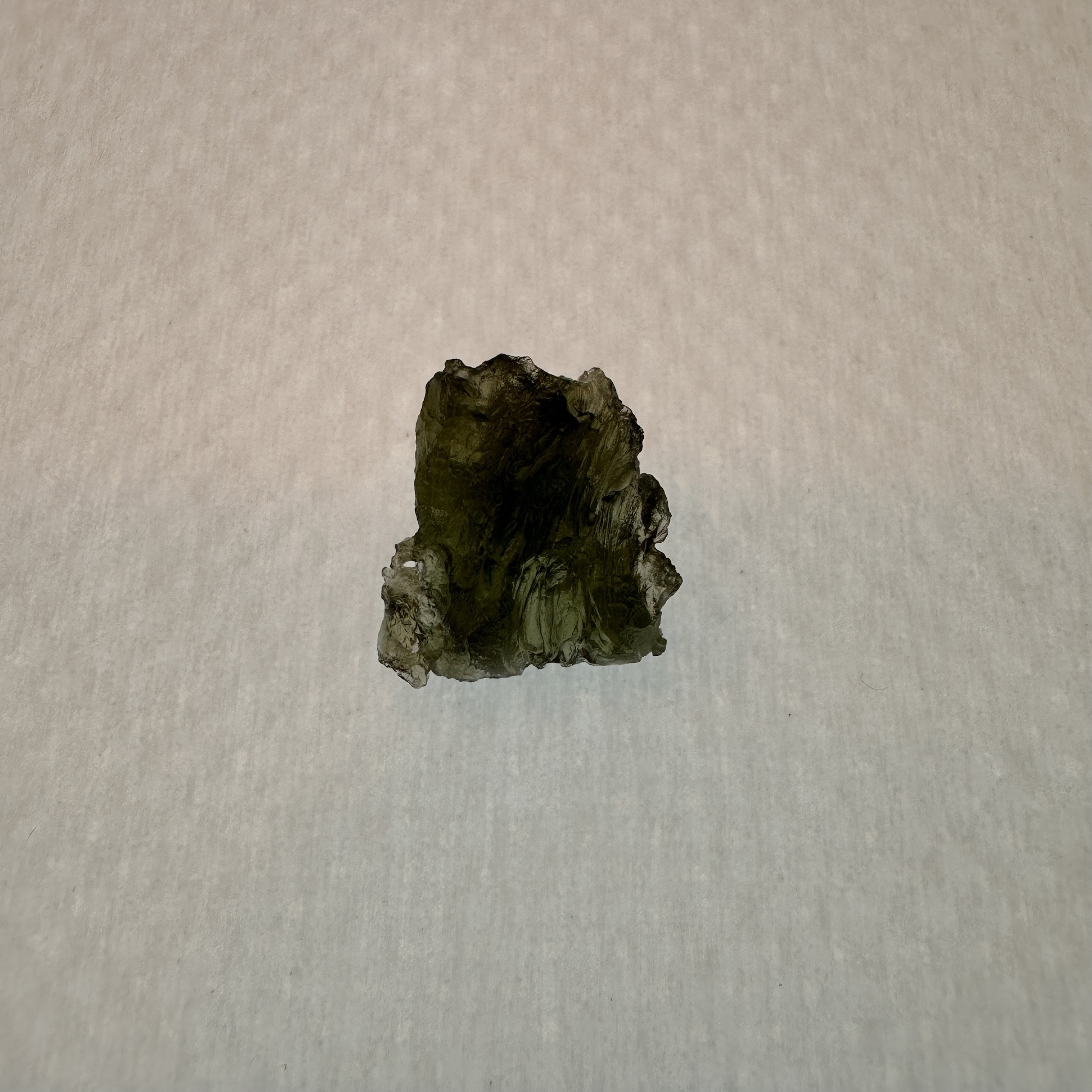 This exceptional Moldavite is approximately 1 inch long by 1 inch wide, and has a beautiful deep green color